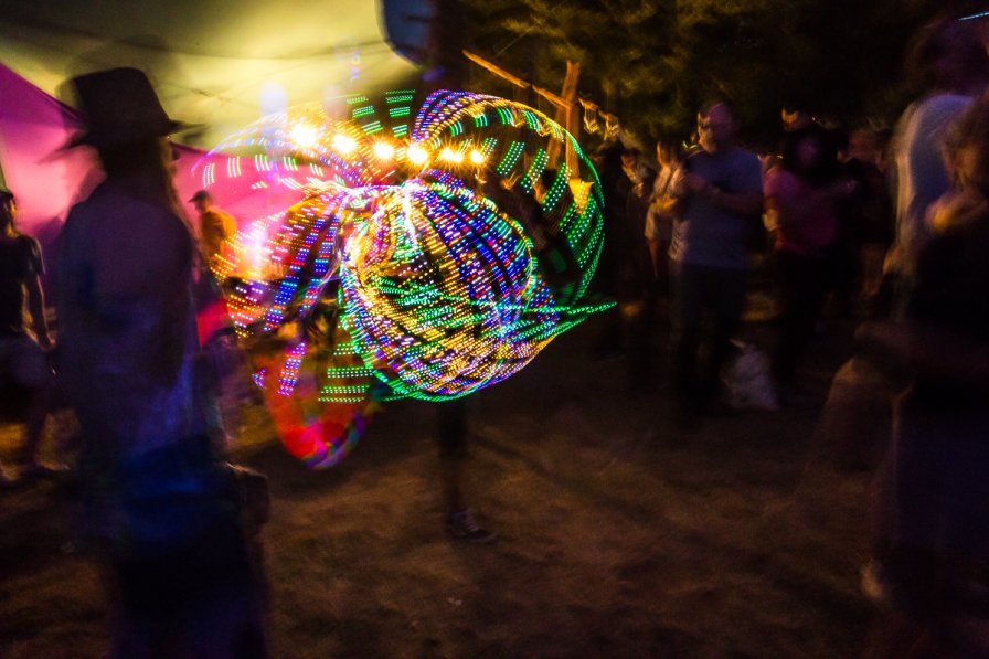 A festival-goer twirls a lighted hula hoop